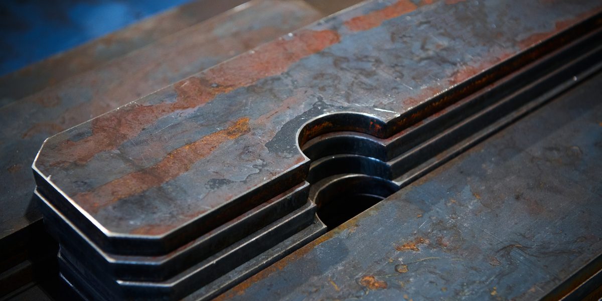 Stacks of different shape workpieces cut of metal sheet for detail making in production plant light storehouse close view